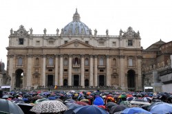 Piazza San Pietro piena di gente che aspetta sotto la pioggia la seconda fumata
